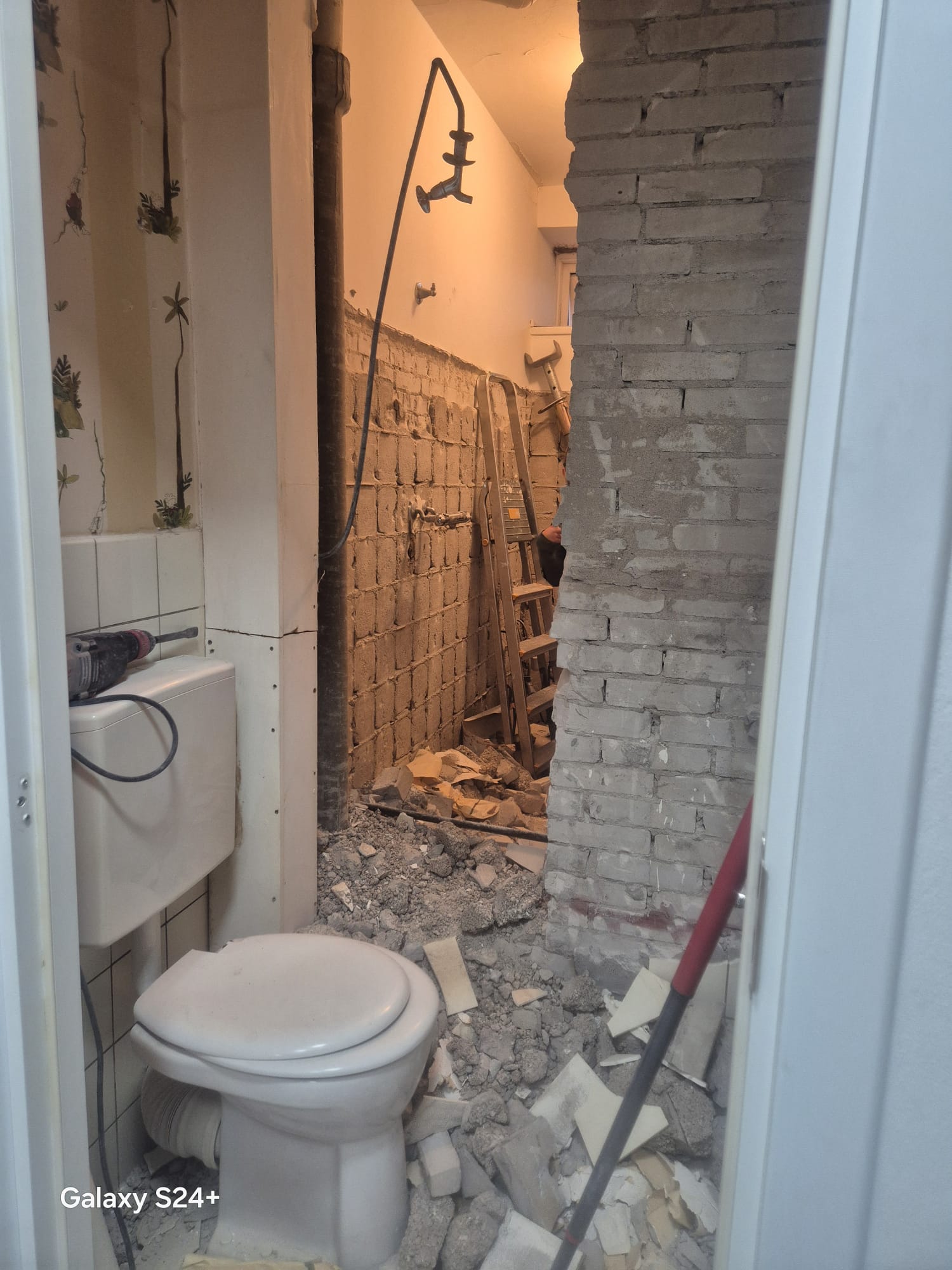 Sloopwerk in de badkamer met verwijderde tegels en puin