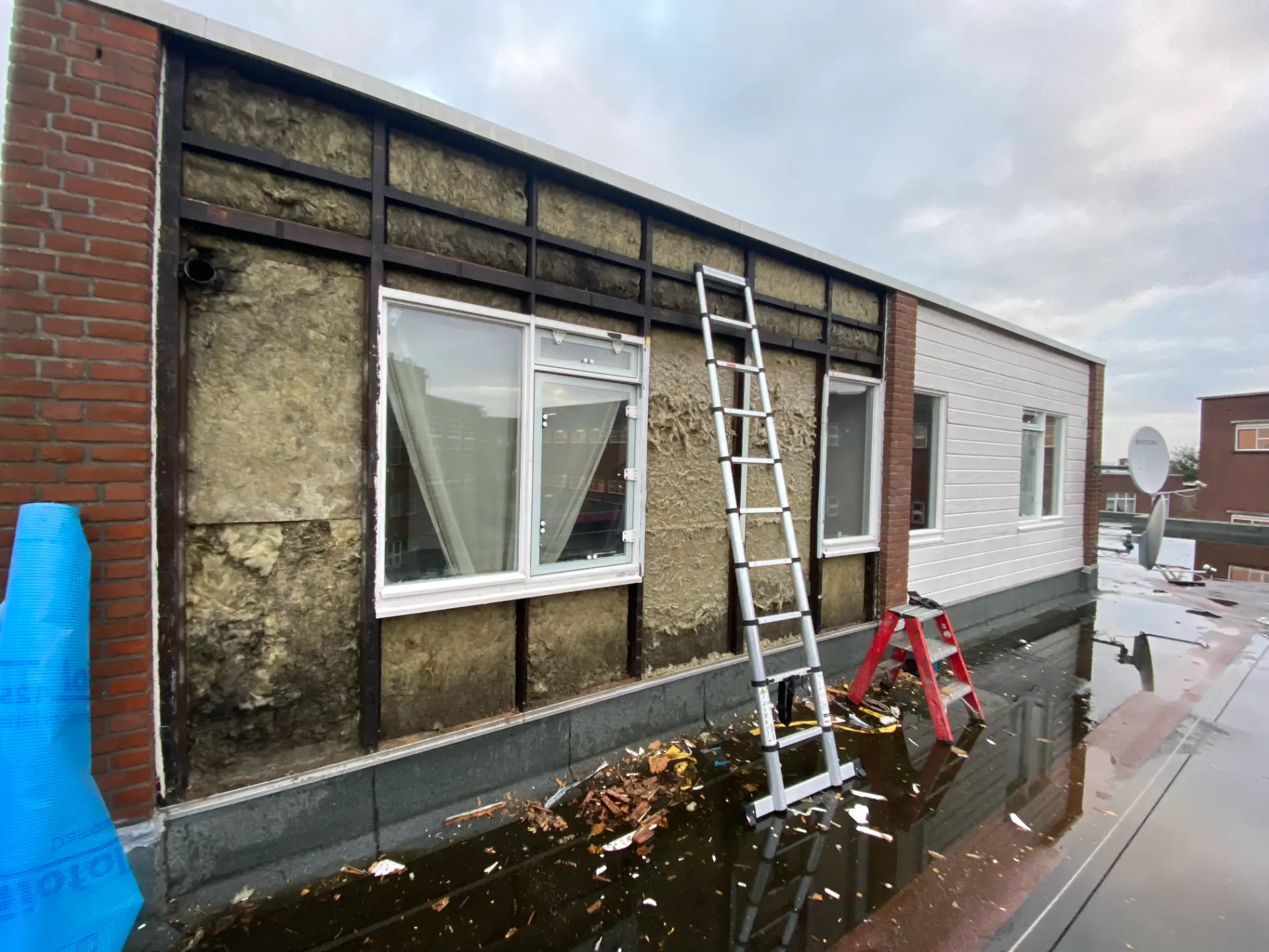 Gevel tijdens demontage met zichtbaar regelwerk en isolatie