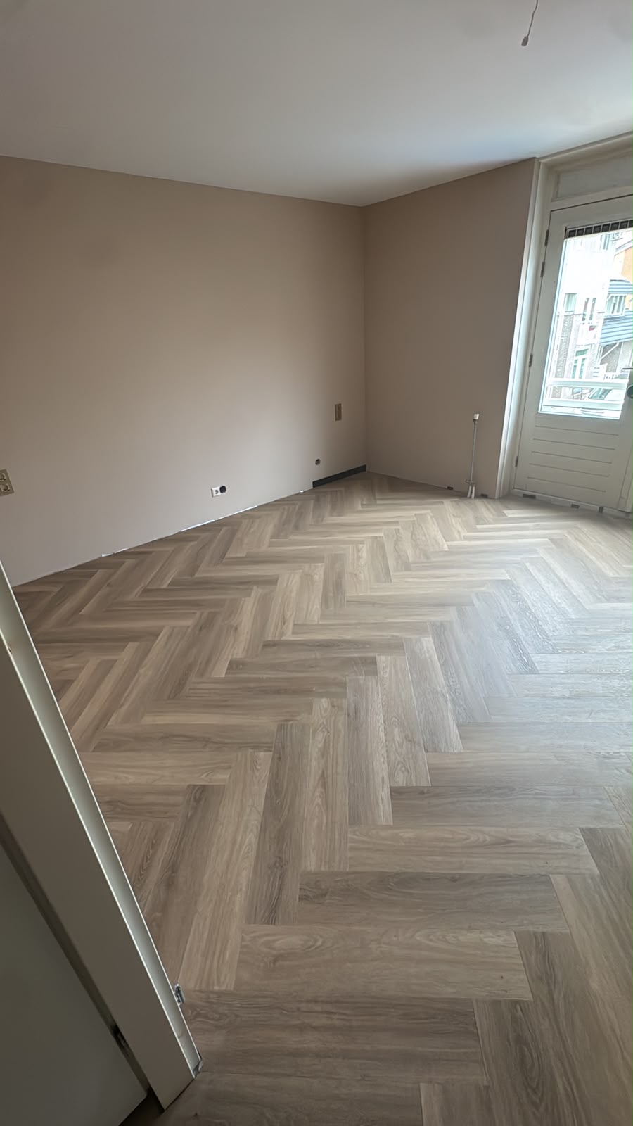 Overzicht van de afgewerkte slaapkamer met visgraatvloer en hoge plinten