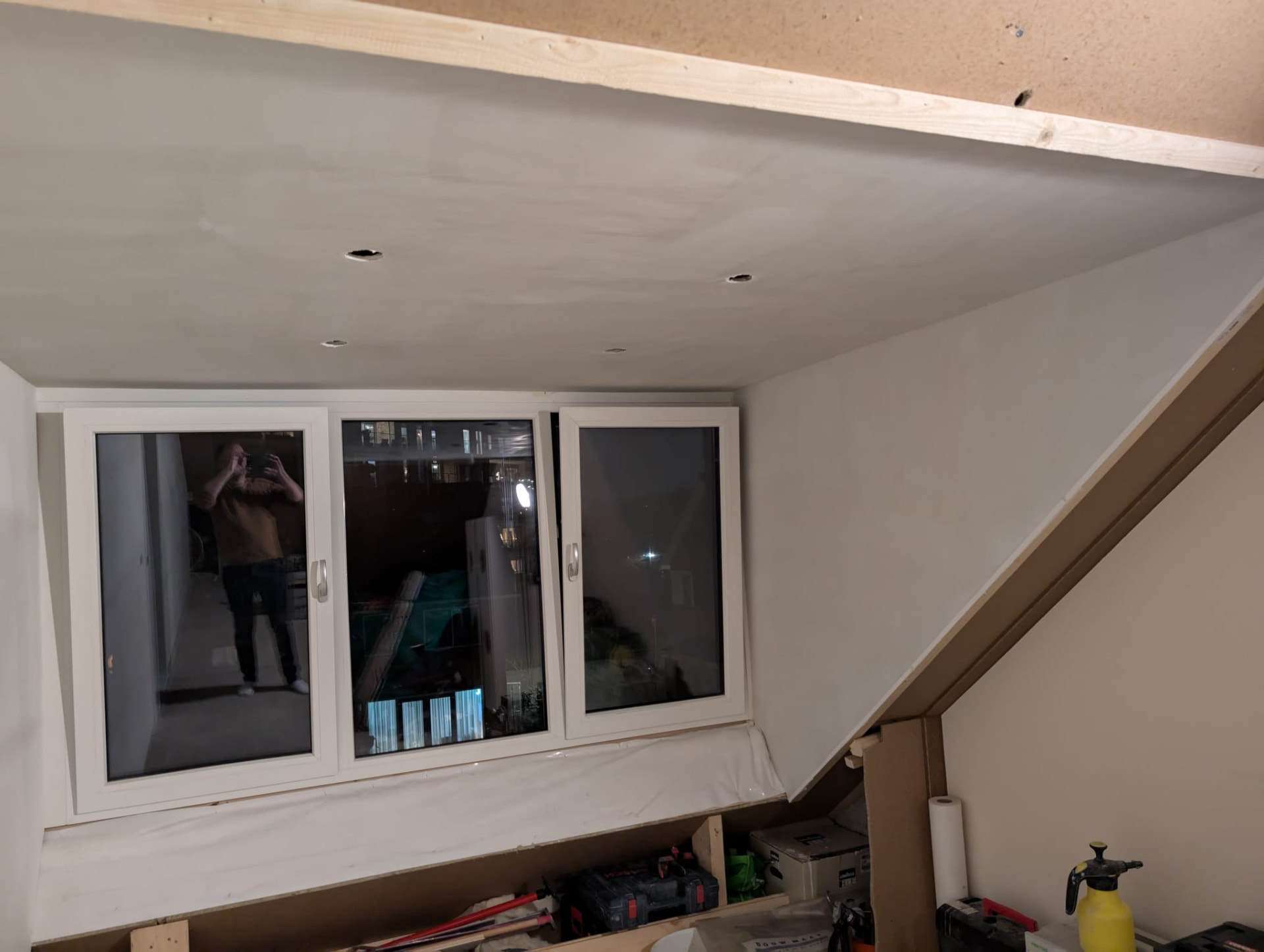Afgewerkt plafond met inbouwspots bij het dakkapelraam